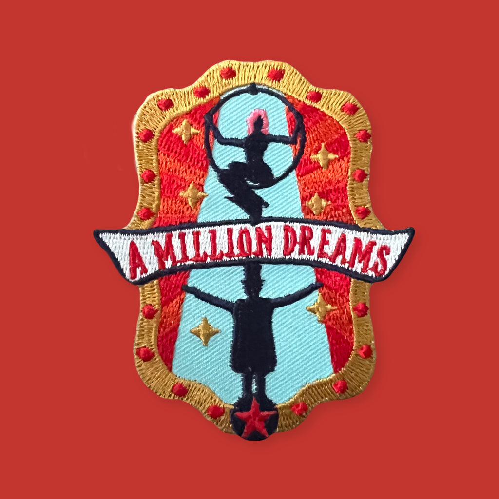 Embroidered patch featuring two silhouetted figures in dynamic poses within a decorative frame, accented with stars and bold red, blue, and gold colors on a solid background.