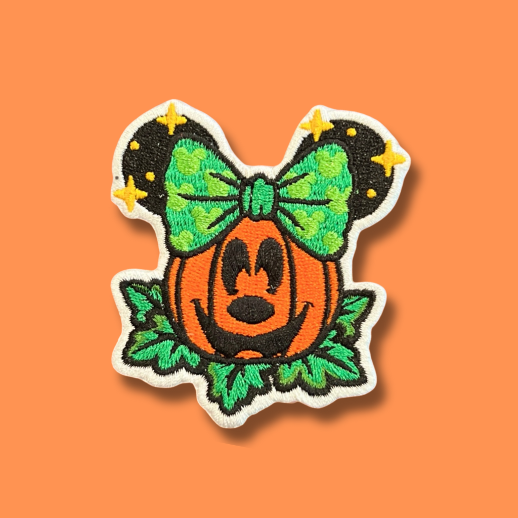 Embroidered Halloween pumpkin patch with a green bow and leafy details.