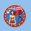 Round embroidered patch featuring a stylized female superhero figure in red, blue, and yellow, surrounded by stars, with a training-themed message and a silhouette figure in the background.