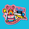 “Embroidered patch featuring a stylized person holding a rainbow cake, surrounded by playful icons like speech bubbles, sparkles, and a rolling pin in bold pink and rainbow colors.”