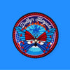 Round embroidered patch featuring a colorful butterfly with red, blue, and white wings, surrounded by stars and a decorative border, set against a blue background with radiant patterns.