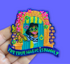 “Embroidered patch held in hand showing a smiling illustrated girl standing in a colorful doorway framed by flowers, holding butterflies, with bright teal, yellow, and pink details.”