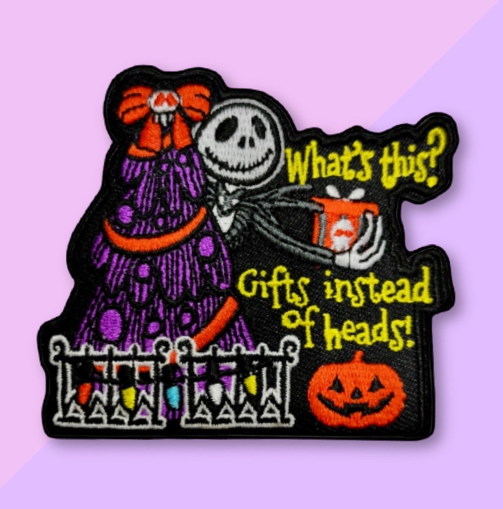 “Embroidered Halloween-themed patch showing a smiling skeleton character in a suit holding a small gift box, standing beside a purple-dressed figure, with a pumpkin and festive decorations.”