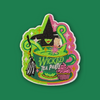 Embroidered patch featuring a stylized witch figure peeking from a green teacup with swirling steam, sparkles, a broom, and a cupcake, in bright green and pink colors on a dark green background.